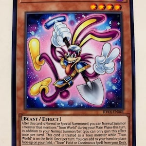 Puede incluir: Una carta coleccionable con el personaje "Funny Dark Rabbit". La tarjeta tiene un borde marrón con el nombre del personaje en la parte superior. La ilustración muestra un conejo morado con detalles amarillos, una pala y un signo de la paz. El texto de la tarjeta está en inglés.