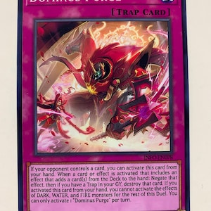 Könnte beinhalten: Dominus Purge, eine rote und schwarze Fallenkarte aus dem Yu-Gi-Oh! Trading Card Game. Die Karte zeigt ein rotes und schwarzes Monster mit leuchtend roten Augen und einem feurigen Hintergrund.