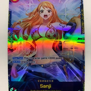 Peut inclure: Une carte à collectionner holographique représentant le personnage Sanji de l'équipage Punk Hazard/Straw Hat. La carte a un fond bleu et violet avec le chiffre 3 et le texte "COUNTER +1000". La carte comprend également le texte "Your Turn This Character gains +3000 power. On K.O. Draw 1 card."