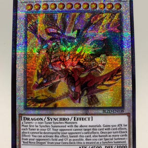 Puede incluir: Una tarjeta coleccionable holográfica con el Dragón Hipernova Rojo. La tarjeta tiene un diseño vibrante y multicolor con una ilustración de dragón. El texto incluye el nombre, los atributos y los efectos del juego. El ataque de la carta es 4500 y la defensa es 3000.