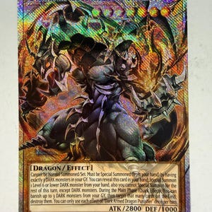 May include: A holographic Yu-Gi-Oh! trading card titled Dark Armed Dragon Punisher. The card features a dark, armoured dragon creature with glowing orange accents. The bottom section contains text detailing the dragon effect, with ATK 2800 and DEF 1000.