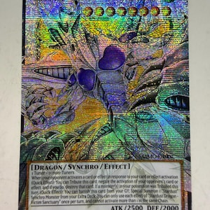 Może przedstawiać: Holograficzna karta kolekcjonerska zatytułowana Stardust Dragon - Victim Sanctuary, przedstawiająca metalicznego smoka z fioletowymi akcentami. Karta zawiera tekst Dragon/Synchro/Effect, ATK/2500, DEF/2000 oraz oznaczenie 1st Edition.