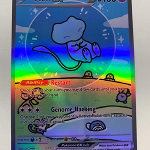 May include: A holographic Pokémon trading card featuring Mew ex. The card has a blue background with a cartoon illustration of Mew. The card text includes "Restart" and "Genome Hacking" abilities, along with other game details. The card is labeled 232/091.