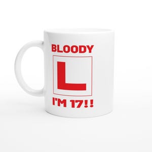 May include: White ceramic mug with a red "L" in a square and the text "BLOODY I'M 17!!" in red. The mug has a curved handle and is set against a white background.