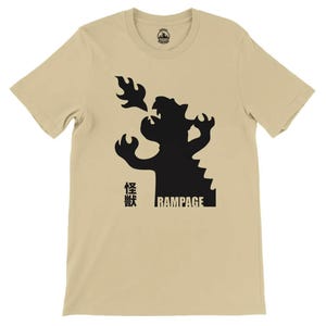 May include: A beige t-shirt with a black silhouette of a dragon breathing fire. The text "Rampage" and Japanese characters are printed on the shirt.