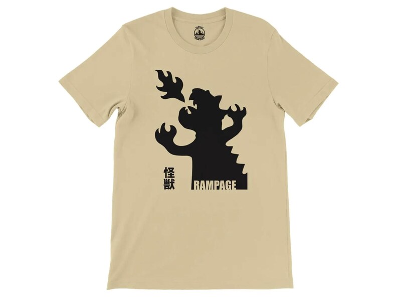May include: A beige t-shirt with a black silhouette of a dragon breathing fire. The text "Rampage" and Japanese characters are printed on the shirt.