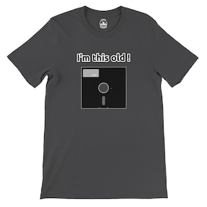 Könnte beinhalten: Ein dunkelgraues T-Shirt mit dem Text "I'm this old!" und einem Schwarzweißbild einer 5,25 Zoll Diskette.