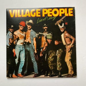 Könnte beinhalten: Ein Vintage-Vinyl-Plattencover mit der Band Village People. Das Cover zeigt die Bandmitglieder in ihren ikonischen Kostümen, darunter ein Bauarbeiter, ein Polizist, ein Cowboy, ein Biker und ein amerikanischer Indianer. Der Albumtitel "Live and Sleazy" ist in gelben Buchstaben auf schwarzem Hintergrund gedruckt.