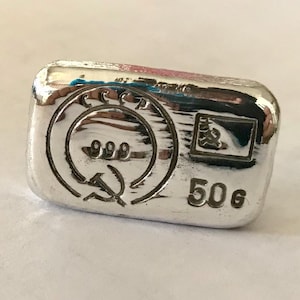 May include: A silver bar with the inscription "50g" and the text "CCCР 999" with a hammer and sickle symbol.