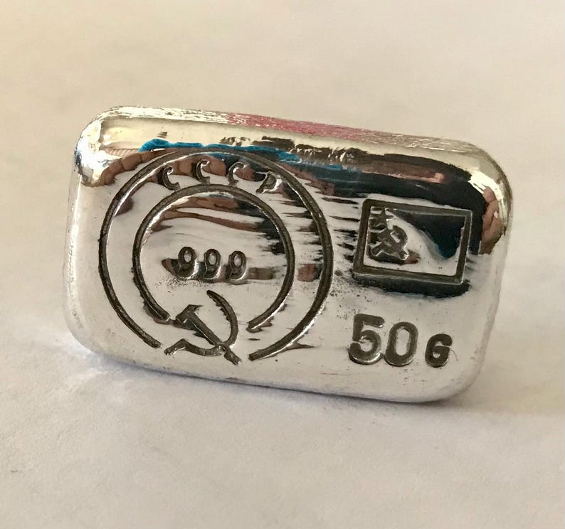 May include: A silver bar with the inscription "50g" and the text "CCCР 999" with a hammer and sickle symbol.