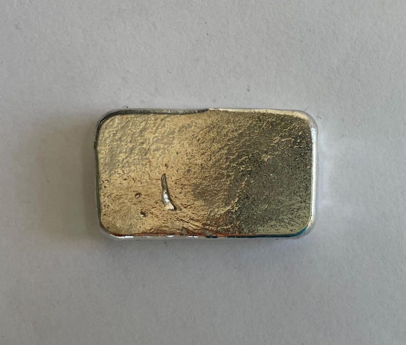 May include: A silver bar with a textured surface.