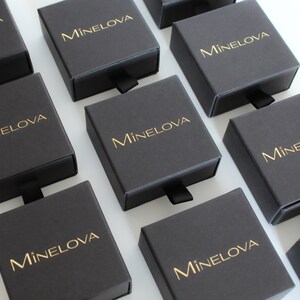 May include: Multiple black boxes with a gold logo that reads "M&iacute;nelova" on each box.
