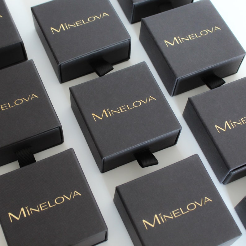 May include: Multiple black boxes with a gold logo that reads "M&iacute;nelova" on each box.