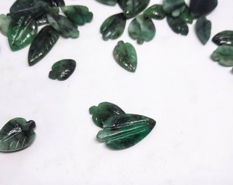 Puede incluir: Una colección de colgantes en forma de hoja de piedra preciosa verde. Las hojas están talladas en una piedra verde oscura y tienen un aspecto natural y orgánico.