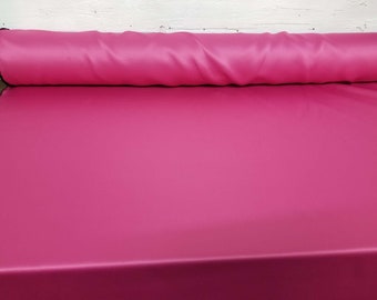Puede incluir: Un rollo de tela de satén rosa brillante. La tela es lisa y brillante.
