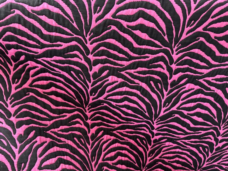 May include: Pink and black fabric with a zebra print pattern.
