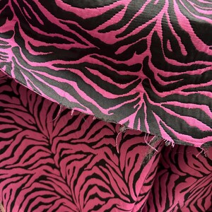 May include: Close-up of pink and black fabric with a zebra print pattern.