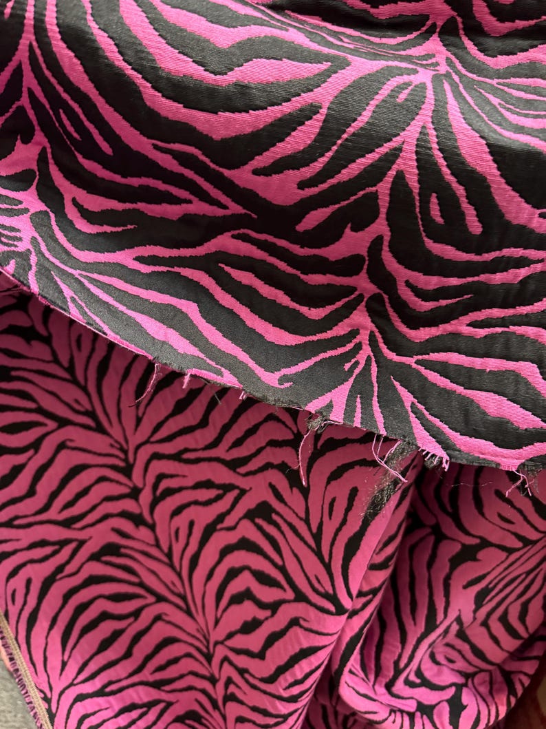 May include: Close-up of pink and black fabric with a zebra print pattern.