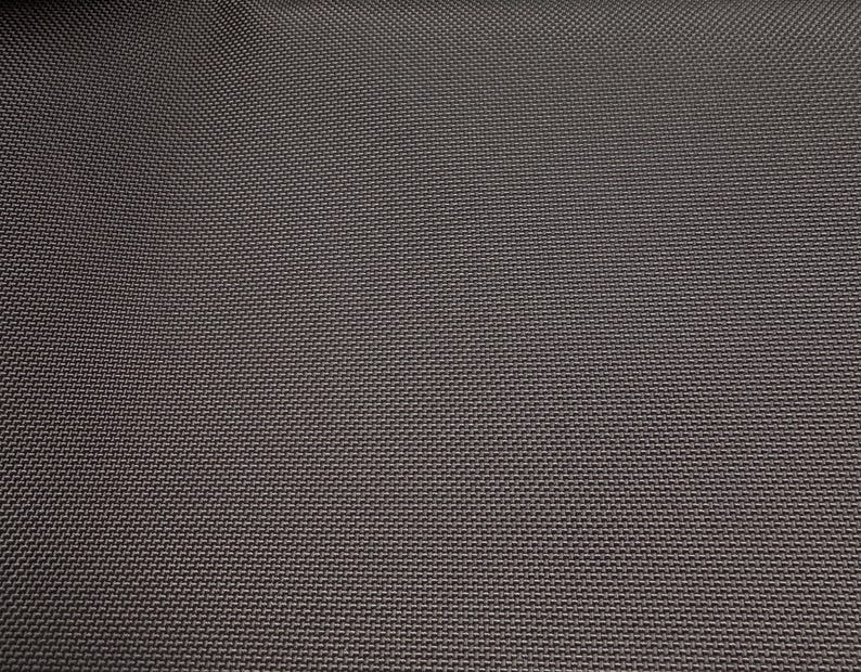 May include: Close-up of a dark gray fabric with a textured weave. The fabric has a subtle sheen and a smooth, even surface.