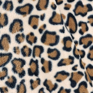 May include: Close-up of a soft, plush fabric with a brown and black leopard print pattern.