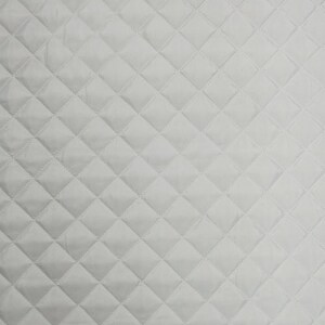 以下が含まれることがあります： ダイヤモンド柄の白いキルト生地。生地は滑らかで、わずかに光沢があります。