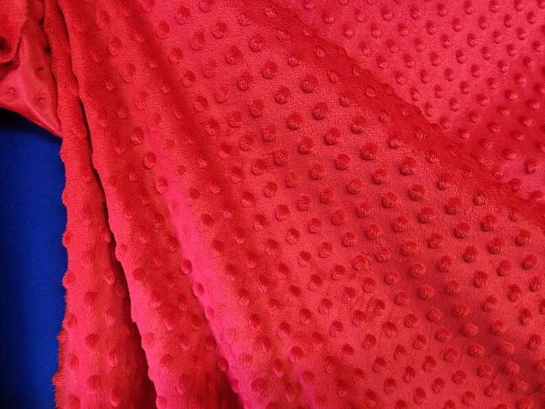 K&ouml;nnte beinhalten: Roter Stoff mit einem strukturierten, gepunkteten Muster. Der Stoff ist weich und pl&uuml;schig.
