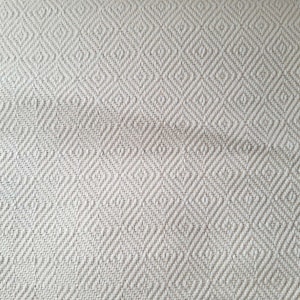 Peut inclure: Gros plan sur un tissu beige avec un motif en losanges. Le tissu a une texture tissée, avec les losanges légèrement en relief. La couleur est un beige neutre, adapté à diverses applications de décoration intérieure.