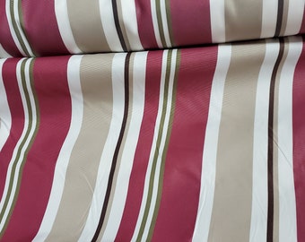 May include: Close-up of a fabric with vertical stripes in burgundy, beige, white, olive green, and dark brown. The fabric is folded over, showing the pattern's repetition and texture. The stripes vary in width.