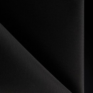 May include: Close-up of a black fabric with a textured weave. The fabric is folded in half, creating a diagonal line.