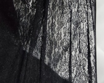 May include: Black lace fabric with a delicate floral pattern. The lace is sheer and has a soft, flowing texture.