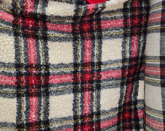 May include: Two pieces of plaid fabric, one with a white background and the other with a cream background. Both fabrics have red, black, and yellow stripes.