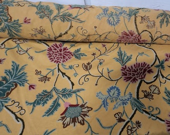 May include: Yellow fabric with a floral pattern featuring blue, green, pink, and brown flowers. The fabric has a vintage style.