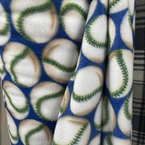 polar fleece with a baseball print. white and red, with the baseballs printed in a stylized, repeating pattern- Sold By The Yard 60" Width