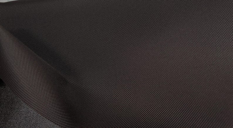May include: Close-up of a dark brown fabric with a textured weave.