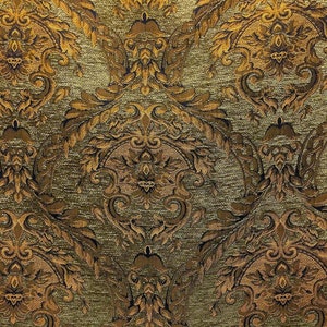 May include: A close-up of a fabric with a gold and brown damask pattern. The fabric has a textured surface and a subtle sheen.