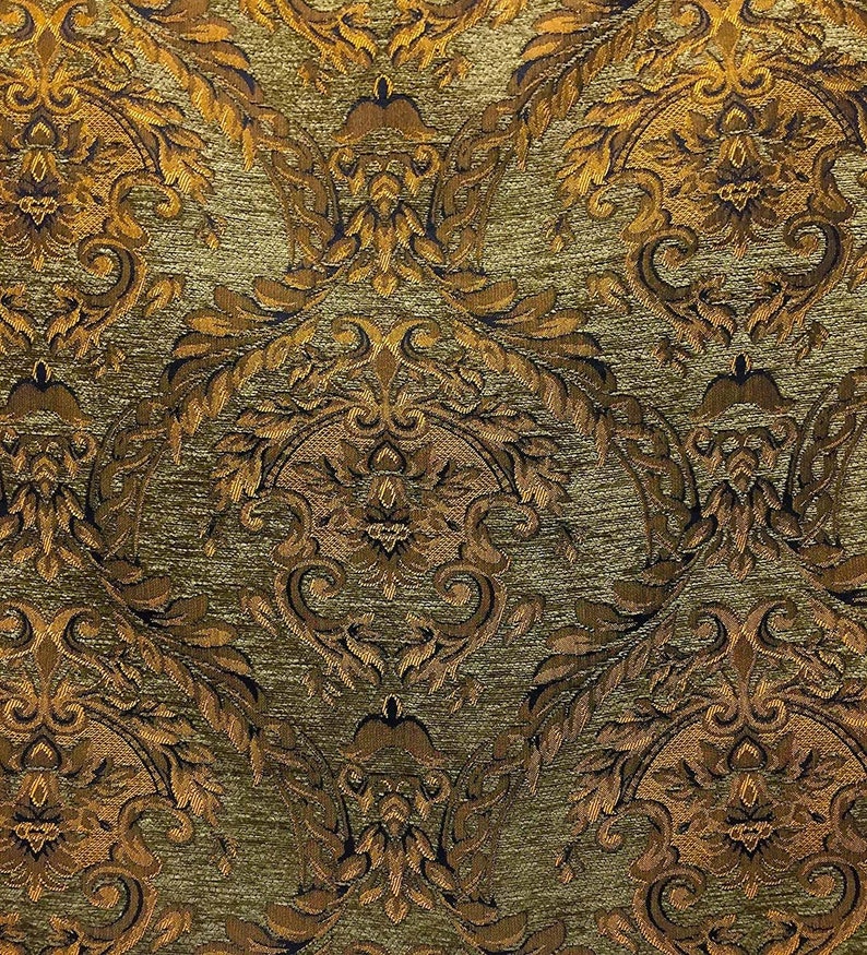 May include: A close-up of a fabric with a gold and brown damask pattern. The fabric has a textured surface and a subtle sheen.