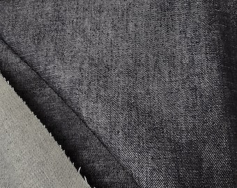 May include: Two pieces of black denim fabric folded over each other. The fabric has a diagonal weave pattern.