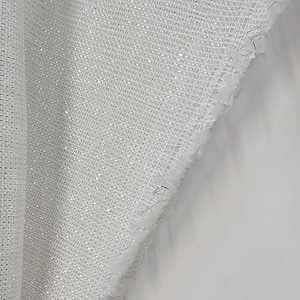 Puede incluir: Tela blanca transparente con un acabado brillante. La tela tiene un patrón de cuadrícula y un borde deshilachado.