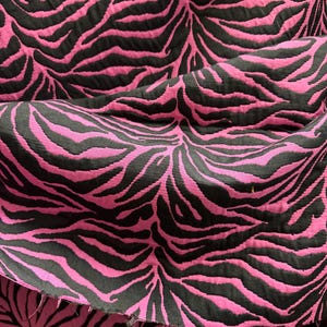 May include: Pink and black fabric with a zebra print pattern.
