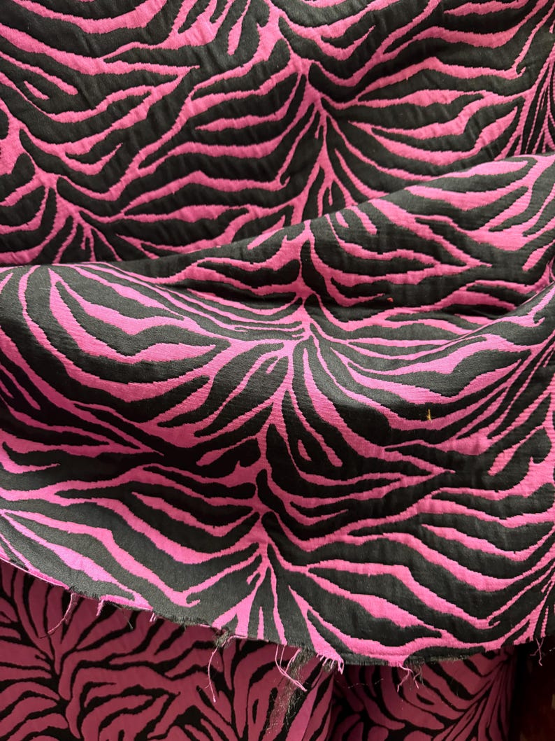 May include: Pink and black fabric with a zebra print pattern.
