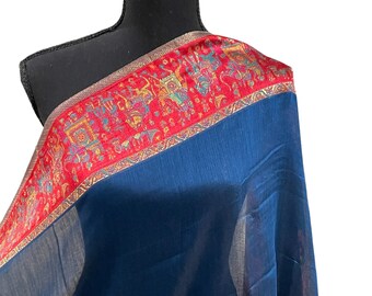 May include: A dark blue sheer scarf with a red and gold border. The border features a repeating pattern of stylized animals and geometric designs.