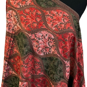 May include: A brown shawl with intricate floral embroidery in shades of pink, red, and green. The shawl is draped over a mannequin.