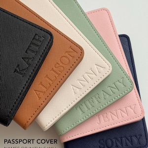 May include: A collection of six rectangular passport covers in black, tan, cream, sage green, light pink, and navy blue. Each cover features a textured surface and a debossed name in the bottom right corner: Katie, Allison, Anna, Tiffany, Jenny, and Sonny.