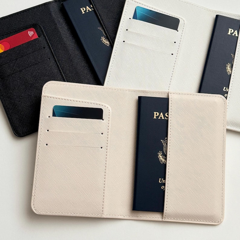 May include: A collection of passport holders in various colors, including black, white, and beige. Each holder features slots for cards and a passport. One holder is open, displaying a blue passport and a credit card.