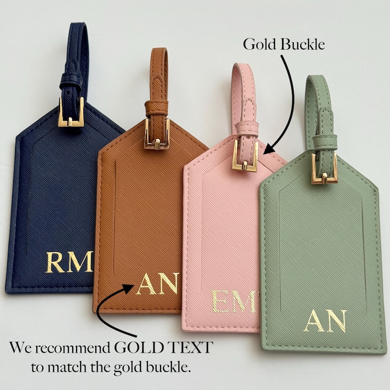 Puede incluir: Cuatro etiquetas de equipaje en azul marino, marr&oacute;n, rosa y verde salvia, cada una con una hebilla y correa doradas. Las etiquetas tienen letras doradas con iniciales. Tambi&eacute;n se ve el texto "We recommend GOLD TEXT to match the gold buckle".