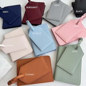 May include: A collection of passport holders and matching luggage tags in various colors including navy, burgundy, gray, black, pink, oyster, sky blue, white, cognac, and sage. Each item features a textured finish and is labeled by color.