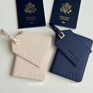 May include: Two United States of America passports are displayed with two personalized travel sets. One set is oyster-colored with "OLIVIA" embossed, and the other is navy blue with "TYLER" embossed. Each set includes a passport holder and luggage tag.