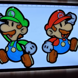 Puede incluir: Dos personajes de dibujos animados, Mario y Luigi, se representan en una pose de carrera. Mario lleva un sombrero rojo y un mono, mientras que Luigi lleva un sombrero verde y un mono. Ambos personajes est&aacute;n delineados en negro y tienen ojos blancos. Los personajes est&aacute;n sobre un fondo blanco con una regla en el fondo.