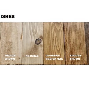 May include: A display of six wood samples labeled WAX FINISHES, showing different stains: Rustic Pine, Medium Brown, Natural, Georgian Medium Oak, Rugger Brown, and Jacobean Dark Oak. Each vertical wood plank displays a unique grain pattern.