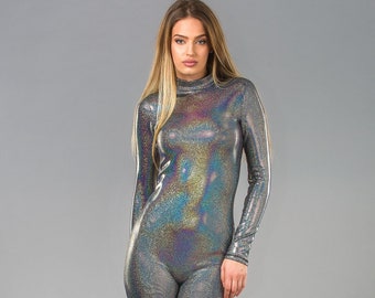 May include: A silver iridescent jumpsuit with long sleeves and a high neck. The jumpsuit is made of a stretchy, shiny fabric and has a fitted silhouette.